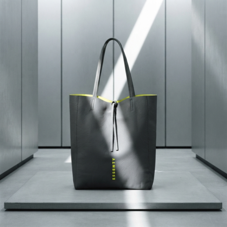 GREY MINIMALIST TOTE BAG FROM CYBER MOOD COLLECTION WITH NEON YELLOW VOLT LINING PLACED ON A BRUTALIST CONCRETE PODIUM