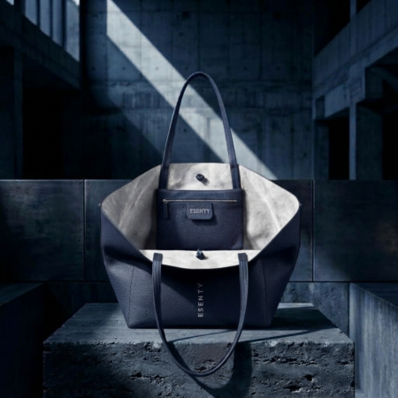 NAVY MINIMALIST TOTE BAG WITH METALLIC SILVER SUEDE LINING OPEN ON A BRUTALIST CONCRETE PODIUM