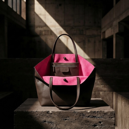 MORO MINIMALIST TOTE BAG WITH HOT PINK SUEDE LINING OPEN ON A BRUTALIST CONCRETE PODIUM