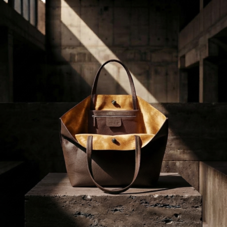 INTERNAL VIEW OF MORO MINIMALIST TOTE BAG WITH GOLD SUEDE LINING OPEN ON A BRUTALIST CONCRETE PODIUM